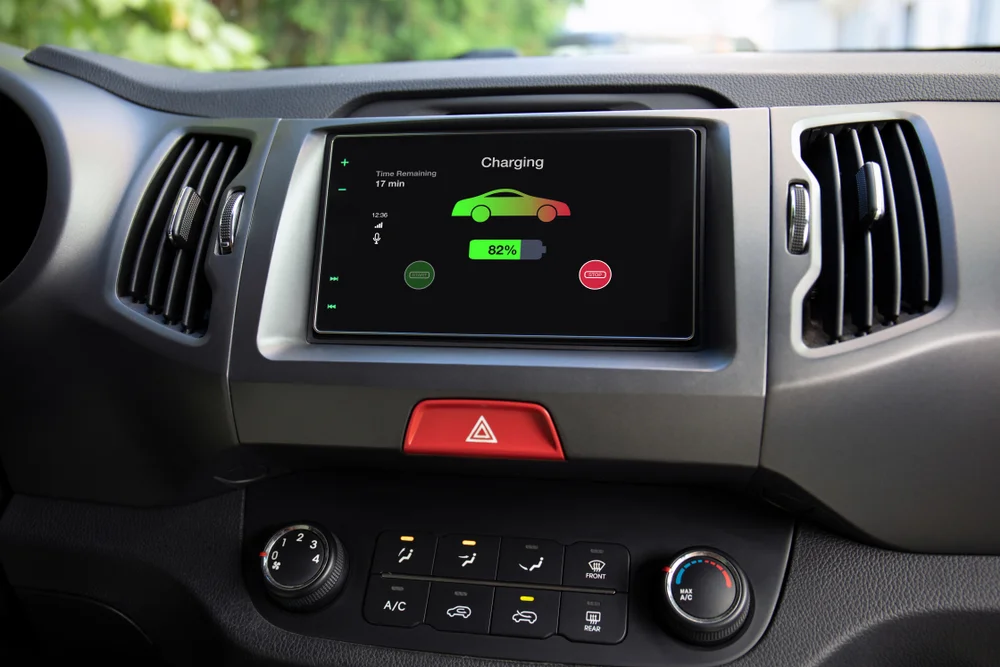 EV dashboard touchscreen showing a charging status screen with battery percentage and time remaining
